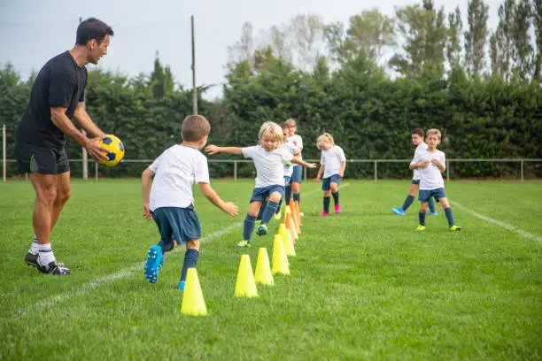 Photo of Young Footballers Practicing Running Drills During Practice