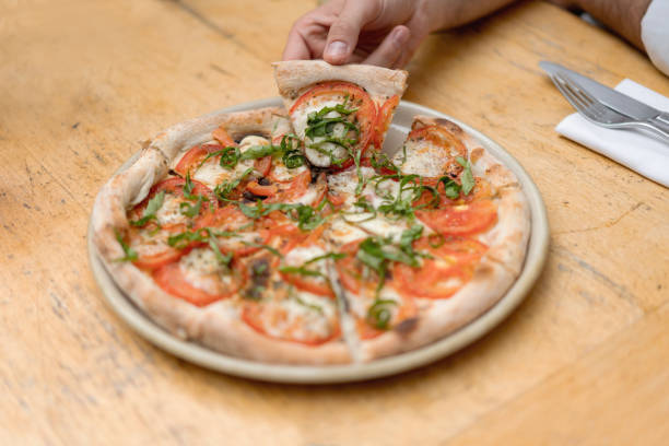 istock Close-up on a person eating pizza 1183994233