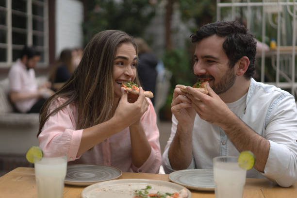 istock Happy friends eating pizza at a restaurant 1183994240