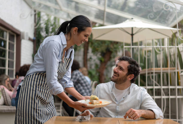 istock Waitress serving food to a man at a restaurant 1183994250