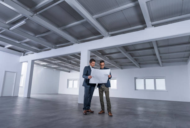 istock Businessmen discussing blueprint 1183994425