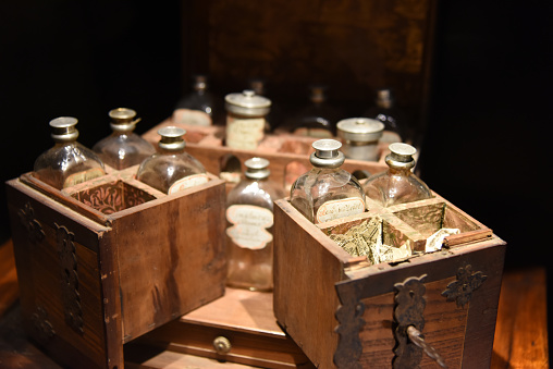 Some really old glass bottles for medical use in a wood box. The image was captured inside of the Muri Abbey in Canton Aargau.