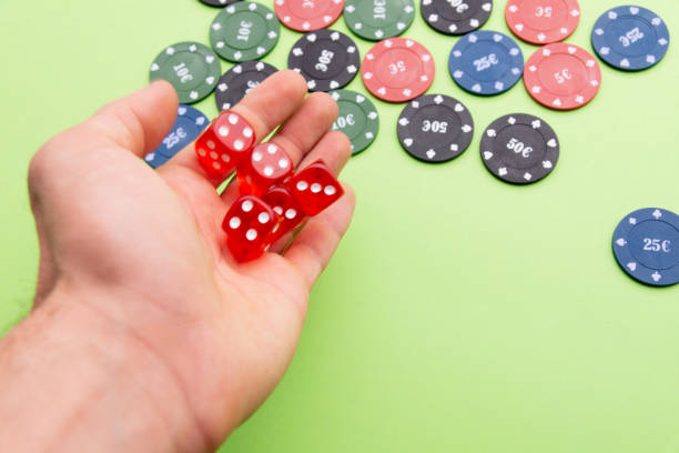 istock man throwing dice. Poker chips. Green background 1183995287