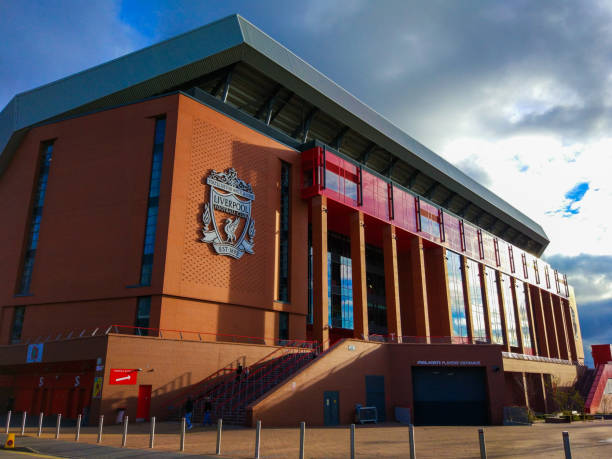 fassade des gebäudes des anfield stadium mit dem abzeichen des fc liverpool und dem eingang der spieler - uefa stock-fotos und bilder