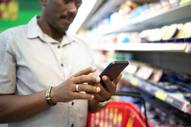 istock Close-up of man using mobile phone in supermarket 1183996391