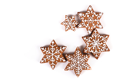 Group of various gingerbread cookies in snowflake shape isolated on white background.