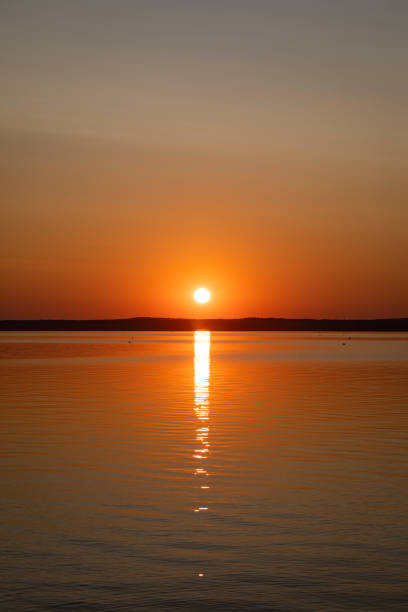 istock Sunrise above horizon forest at lake 1183996959