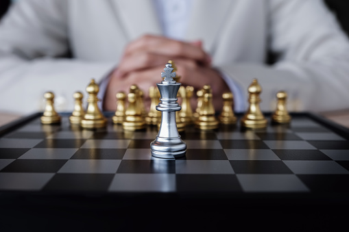 Close-up of cream coloured king chess piece checkmate.