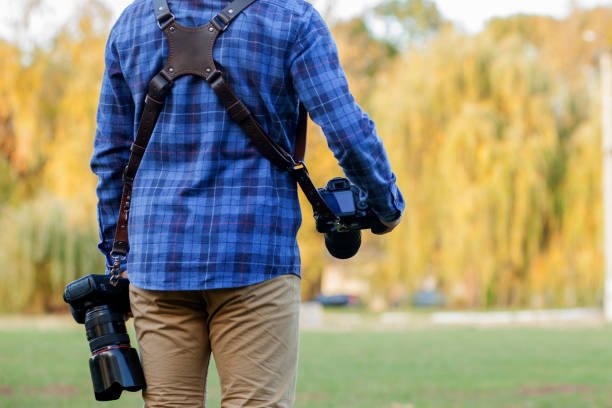 istock Professional photographer in action with two cameras on a shoulder straps 1183999014
