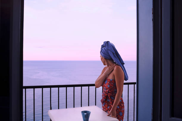 istock Woman on a balcony facing the sea 1183999701