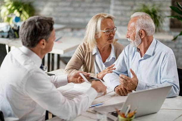 istock Senior couple communicating while having a meeting with insurance agent in the office. 1183999711