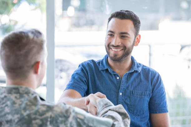 istock Young man shakes hands with military recruiter 1183999799