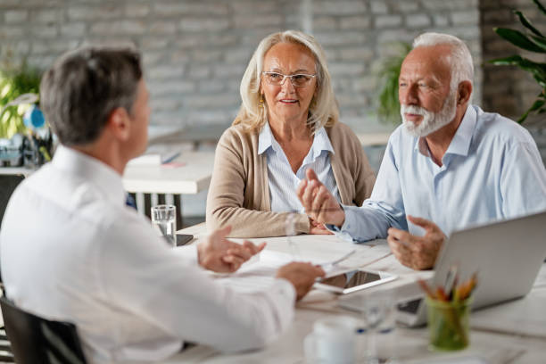 istock Smiling mature couple communicating with insurance agent in the office. 1183999939