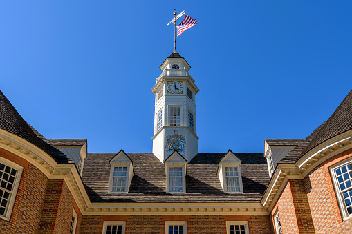 A replica Grand Union Flag, the first national flag of USA, flying at top of bell tower of the Capitol Building in Williamsburg, Virginia, USA.