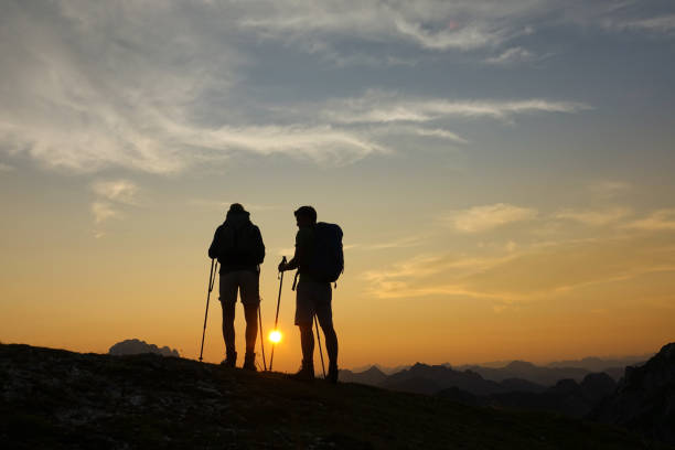 istock SILHOUETTE: Unrecognizable hikers watch the sunset from a peak in the Alps. 1184001092