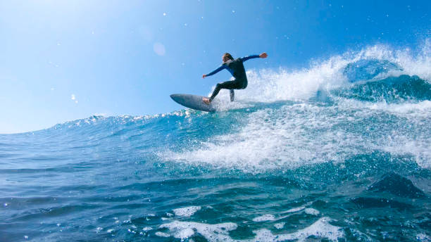 flara słońca: fajny gość surfer rzeźbi piękną niebieską falę rur w pobliżu fuerteventura - lens barrel zdjęcia i obrazy z banku zdjęć
