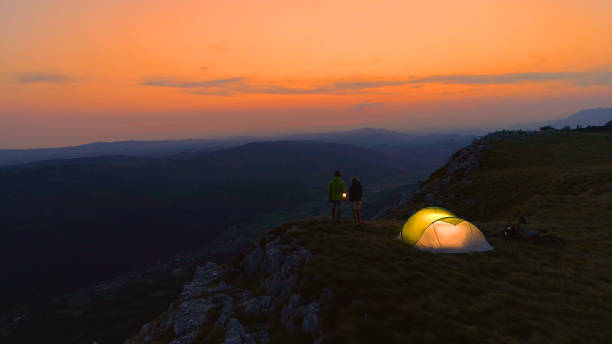 istock DRONE: Flying above a young couple talking by lantern on a calm summer evening. 1184002314