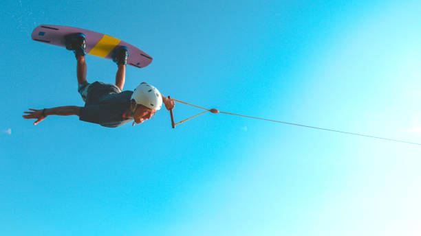 istock SUN FLARE: Awesome wakesurfer flies across the sunny sky and does a spin trick. 1184002554