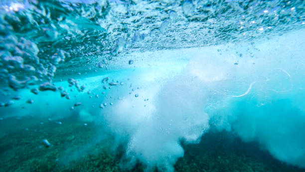 istock UNDERWATER: Bubbles rise from the depths after barrel wave rushes over camera 1184002661