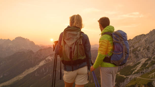 istock CLOSE UP: Unrecognizable hiker couple watching the sunset from the mountaintop. 1184003405