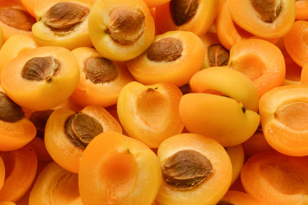 istock Ripe juicy orange apricots slices fruit background. 1184004062