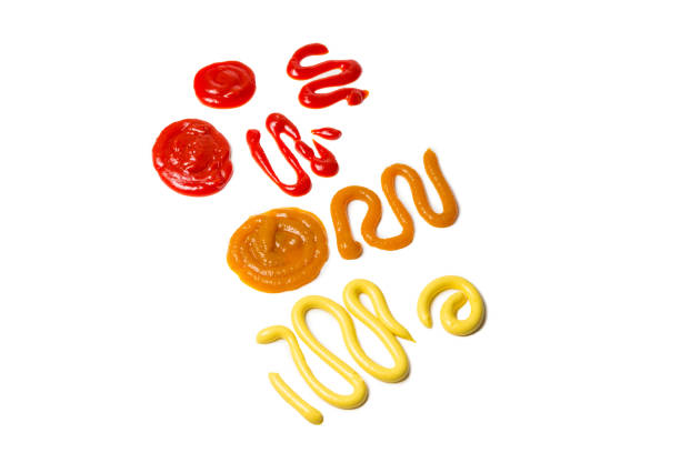 istock Ketchup and yellow sauce splashes isolated on white background. 1184004228