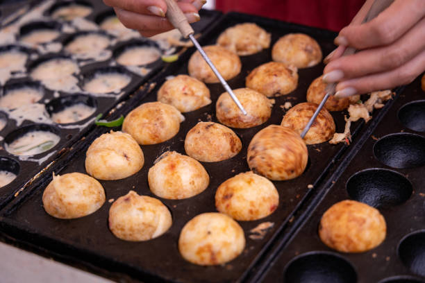 Hands of chef cooking Japanese snack food "Takoyaki" Hands of chef cooking Japanese snack food "Takoyaki" takoyaki photos stock pictures, royalty-free photos & images