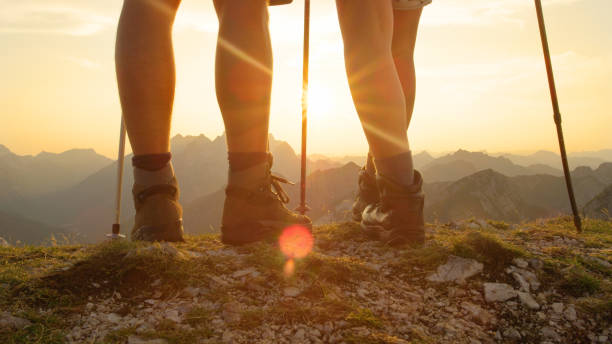 istock LENS FLARE: Unrecognizable active tourists walk up the mountain peak at sunrise. 1184004543