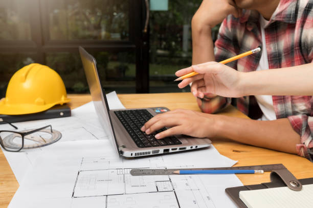istock Group of two coworkers working with blueprint in office. co-working teamwork concept. 1184006020