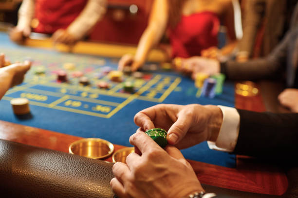 istock Chips in the hands of a man at a casino roulette table. 1184006199