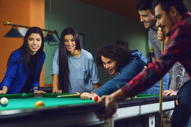 gli amici giocano a biliardo al bar. - pool game pool table aiming men foto e immagini stock