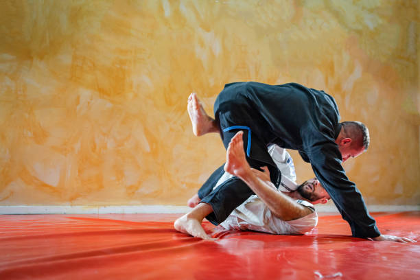 istock Two brazilian jiu jitsu athletes working on BJJ guard position at the training sparring or drilling fighters at the academy class 1184008719