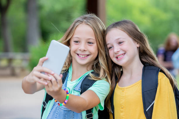 istock Young female students take selfie before entering school 1184008835