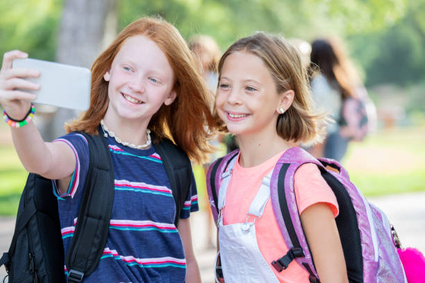 istock Female elementary students take selfie together on first day of school 1184008847
