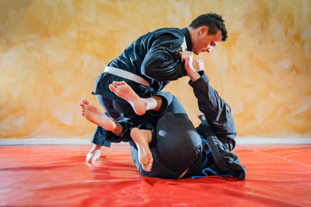 istock Two brazilian jiu jitsu athletes working on BJJ guard position at the training sparring or drilling fighters at the academy class 1184009613