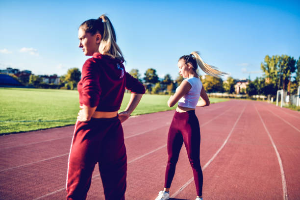 istock Two Female Beauties Warming Up On Track Before Training 1184010652