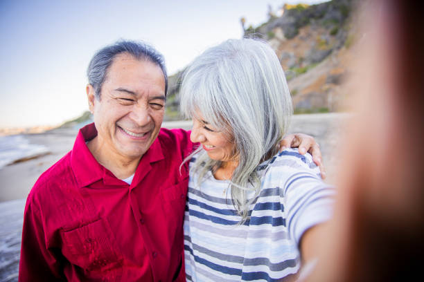 istock Senior Hispanic Couple Taking Selfie at the Beach 1184013905
