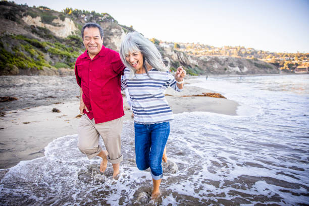 istock Senior Hispanic Couple Walking Along the Beach 1184013982