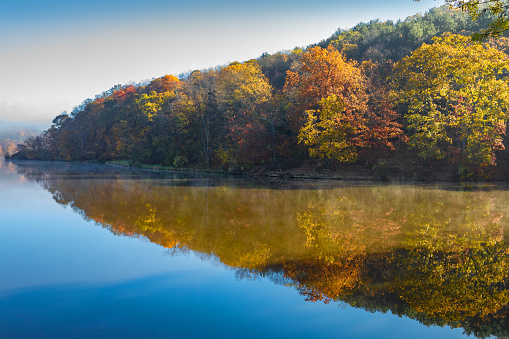 Redlections of fall trees in a beautiful still lake in Pennsylvania, USA.