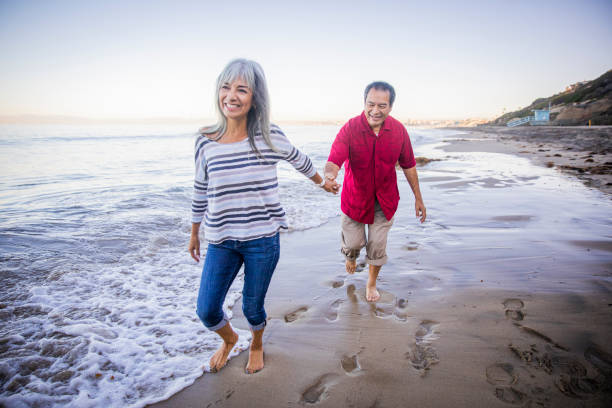 istock Senior Hispanic Couple Walking Along the Beach 1184014064