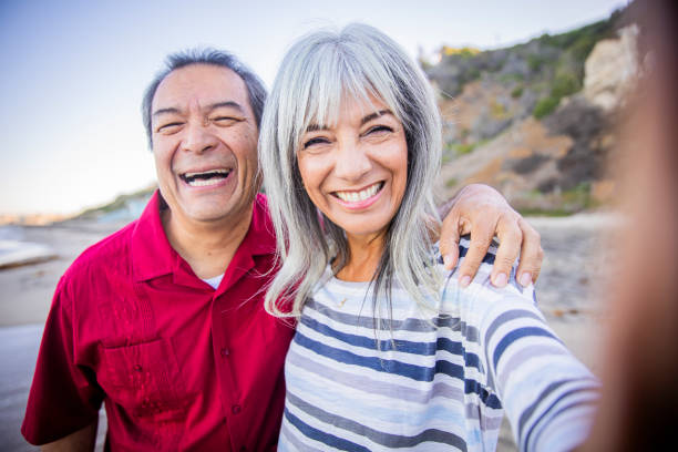 해변에서 셀카를 찍는 수석 히스패닉 커플 - running cheerful outdoors senior couple 뉴스 사진 이미지