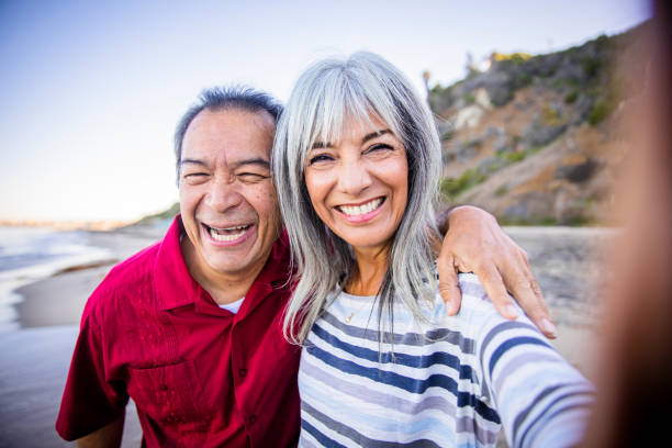 istock Senior Hispanic Couple Taking Selfie at the Beach 1184015257
