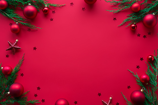 Merry Christmas red background decorated with happy 2020 new year tree branches and baubles stars, winter holiday card decorations festive merry xmas concept, flat lay, above top view, copy space