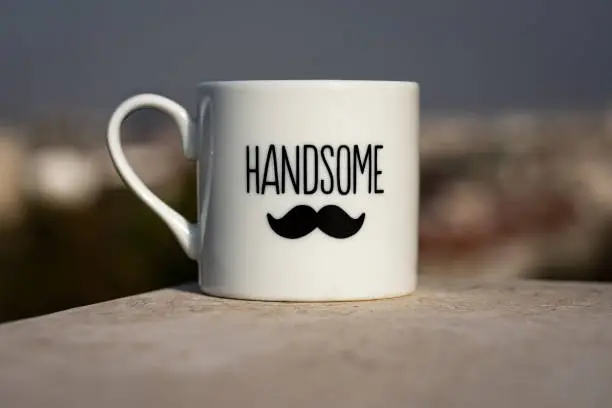 Little cup of coffee with the word "handsome" and a moustache