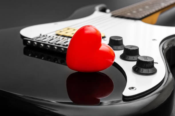 Red heart on electric guitar. Loving music.