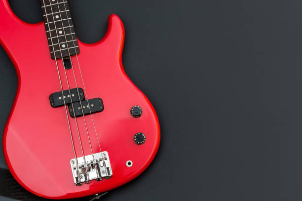 Red electric bass guitar on black. Space for text. Red electric bass guitar on black. Space for text. bass guitar stock pictures, royalty-free photos & images