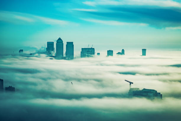 Power plant chimney in the fog. Top of the structure seen through the clouds. Gariūnai, Vilnius, Lithuania. Selective focus on the details, blurred background.