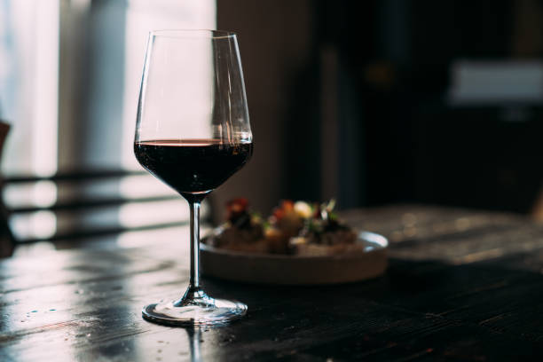 Glass with red wine on wooden table
