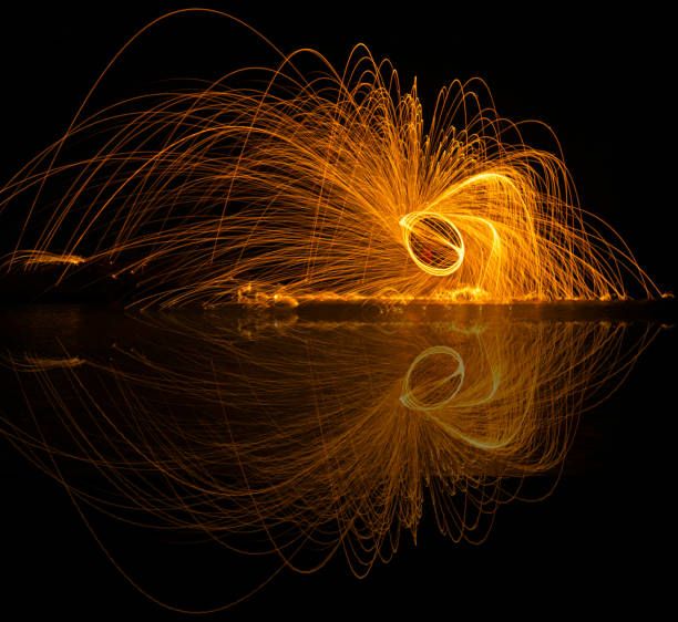 linee leggere di lana d'acciaio con lunga esposizione e riflessione in acqua. - blurred motion circle reflection illuminated foto e immagini stock