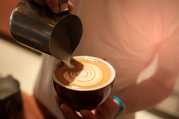 istock Barista holding coffee cup and make latte art coffee 1184022161
